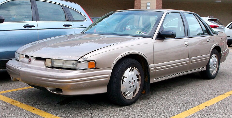 1997 Oldsmobile Cutlass Supreme SL in Light Sandrift Metallic, front left, 07-24-2022