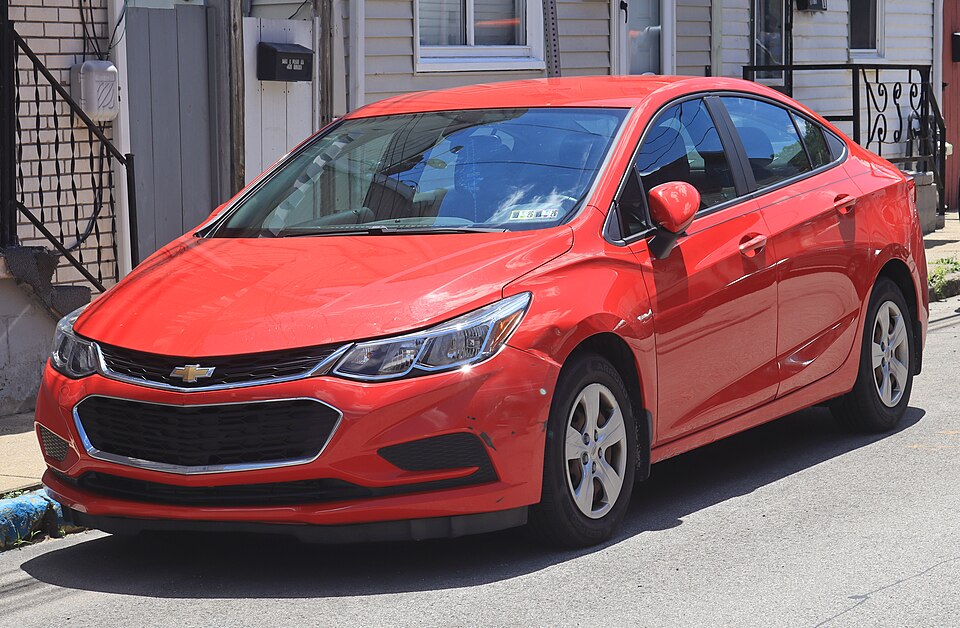 2017 Chevrolet Cruze LS in Red Hot, front left, 06-13-2026