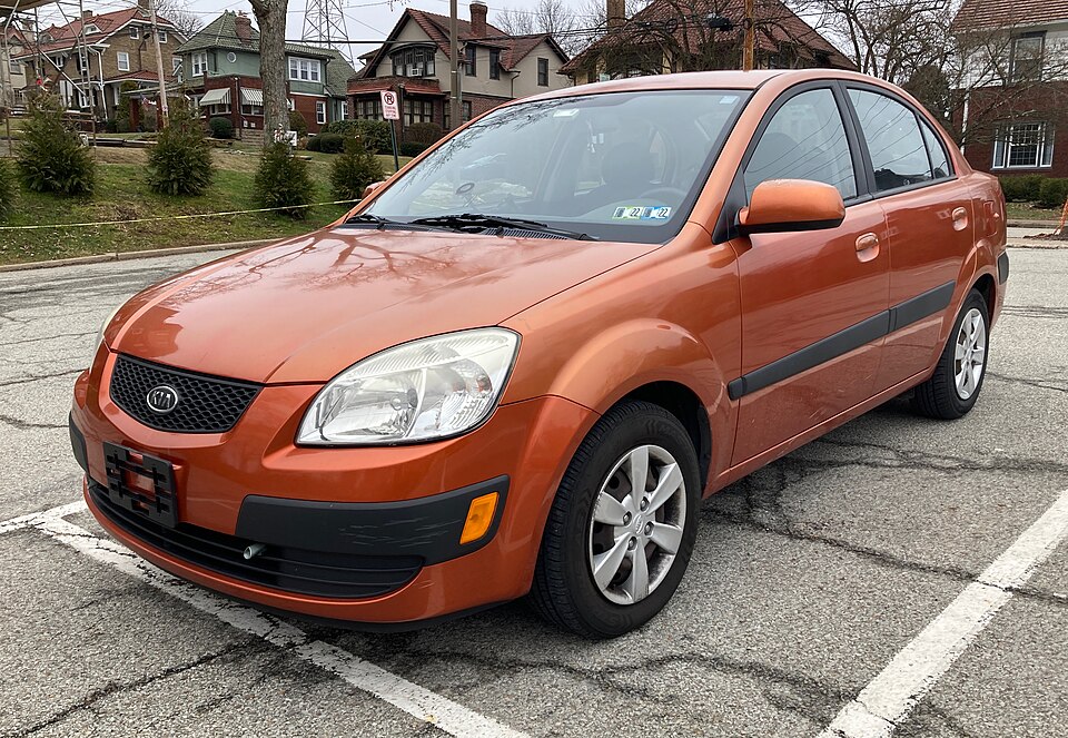 2009 Kia Rio LX sedan in Sunset Orange, front left, 02-23-2022