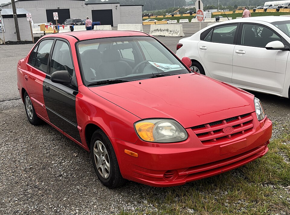 2003 Hyundai Accent GL sedan in Retro Red, front right, 08-15-2026
