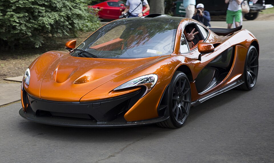 2014 McLaren P1 (Volcano Orange, front left), leaving Greenwich 2018