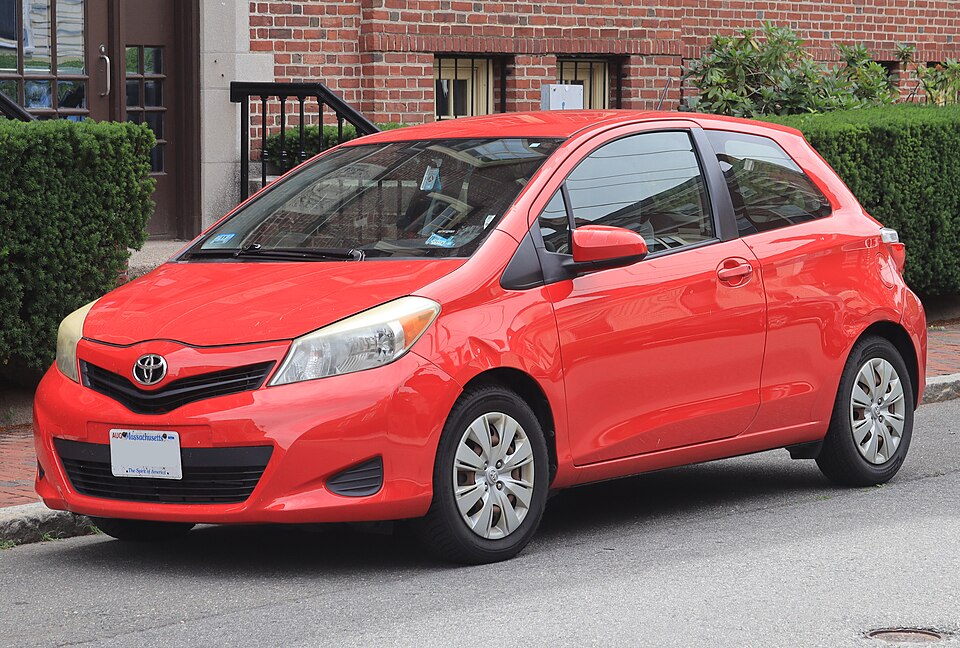 2012 Toyota Yaris 3-door L in Absolutely Red, front left, 07-06-2026