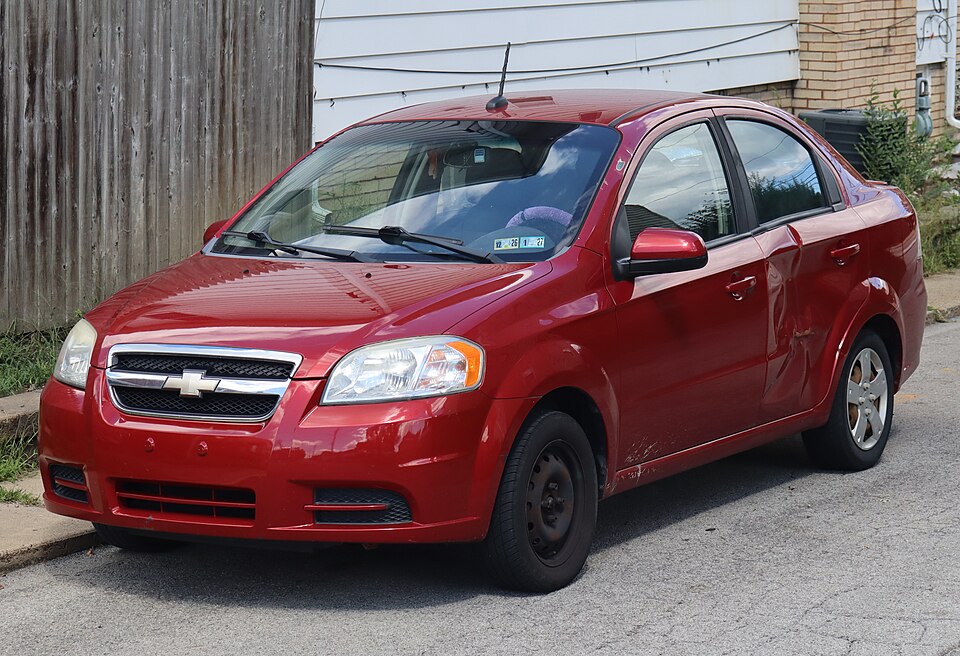 2010 Chevrolet Aveo LS Sedan in Sport Red, front left, 09-06-2026