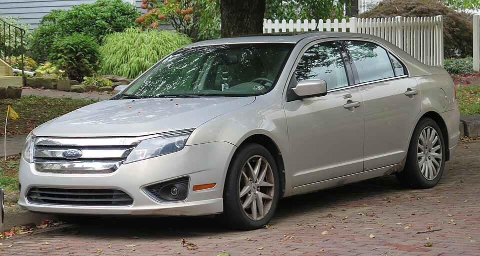 2010 Ford Fusion in Smokestone Metallic, front left, 10-12-2025