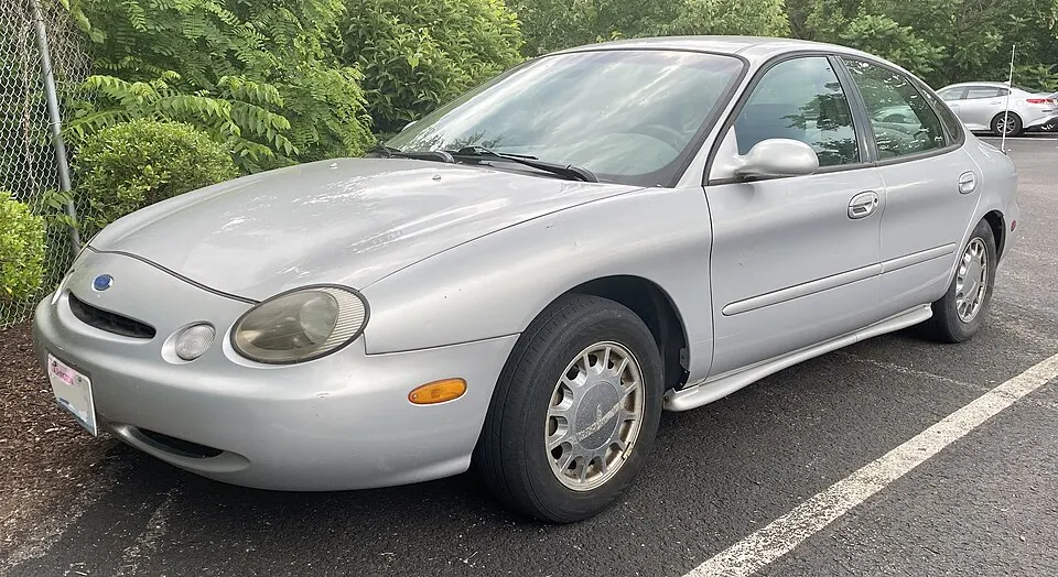 1996 Ford Taurus LX in Silver Frost Clearcoat Metallic, front left, 06-06-2022, photographed in United States