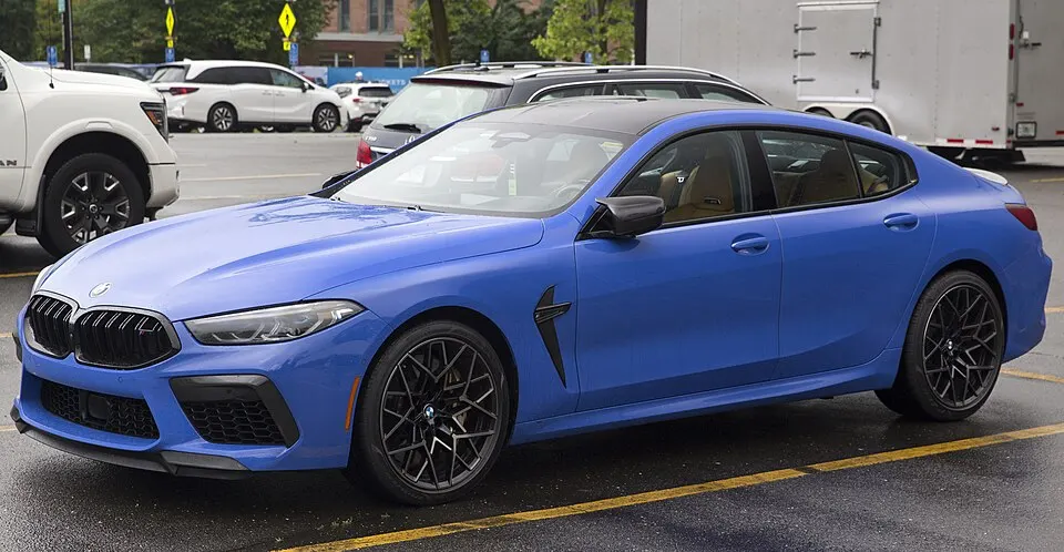 2025 BMW M8 Competition Gran Coupé in Marina Bay Blue Metallic, front left, photographed in United States