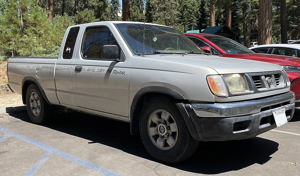 1998 Nissan Frontier XE King Cab in Platinum Gold Metallic, front right, 08-10-2022, photographed in United States